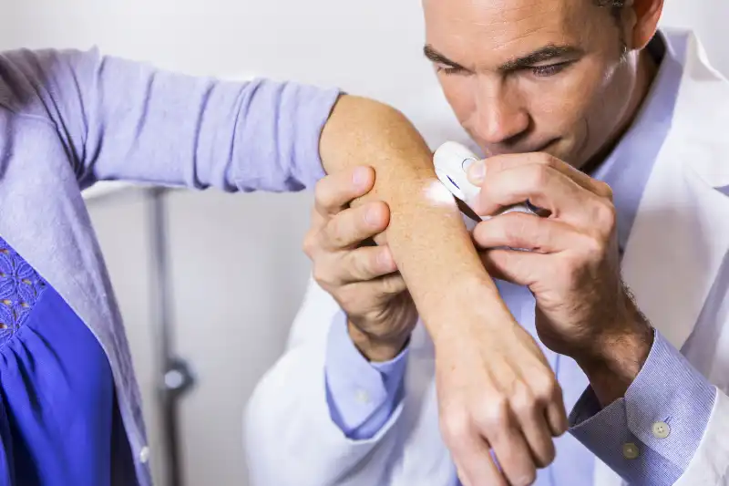 Close-up of a medical professional using an instrument to treat the forehead.